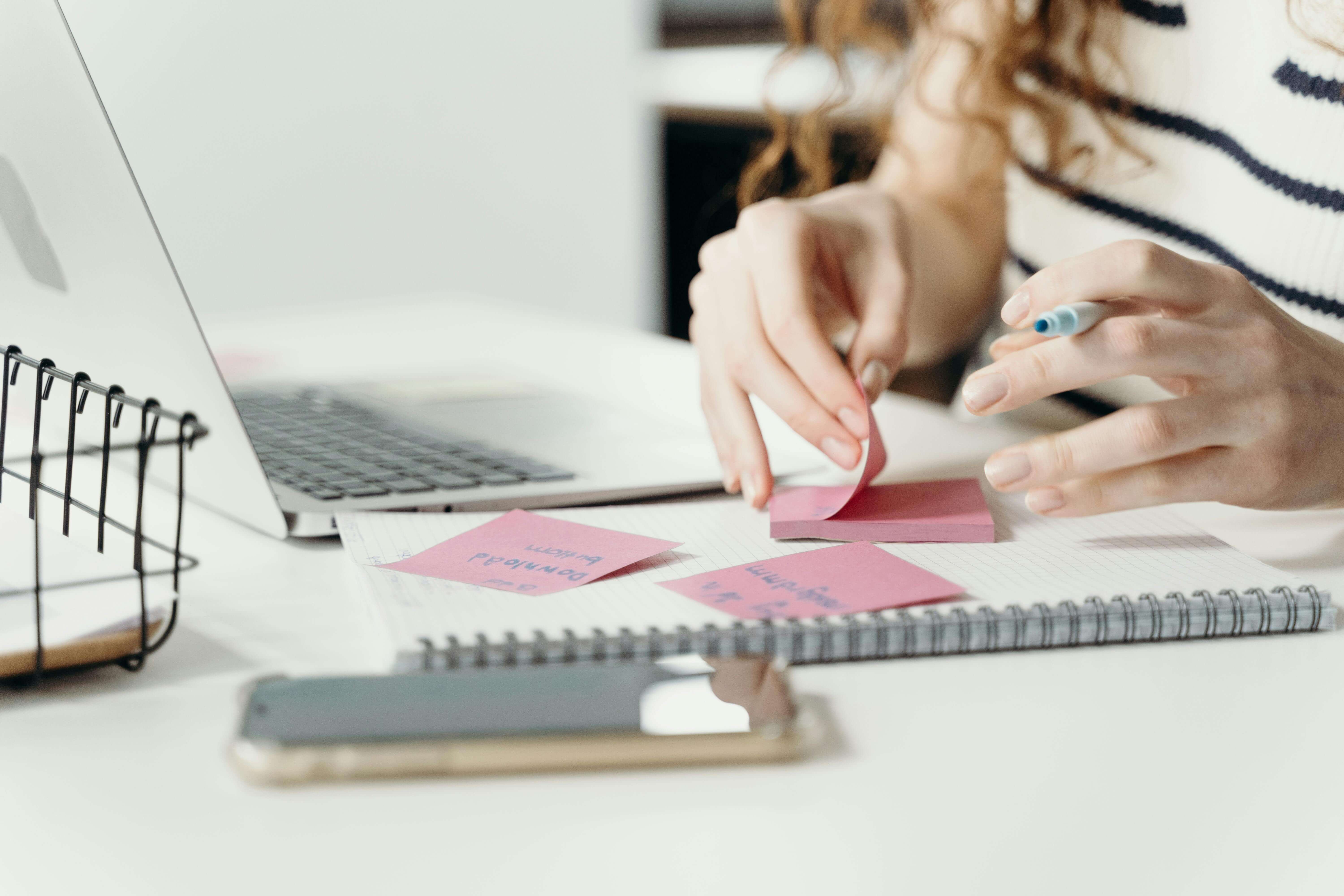 Person Writing on a Sticky Note