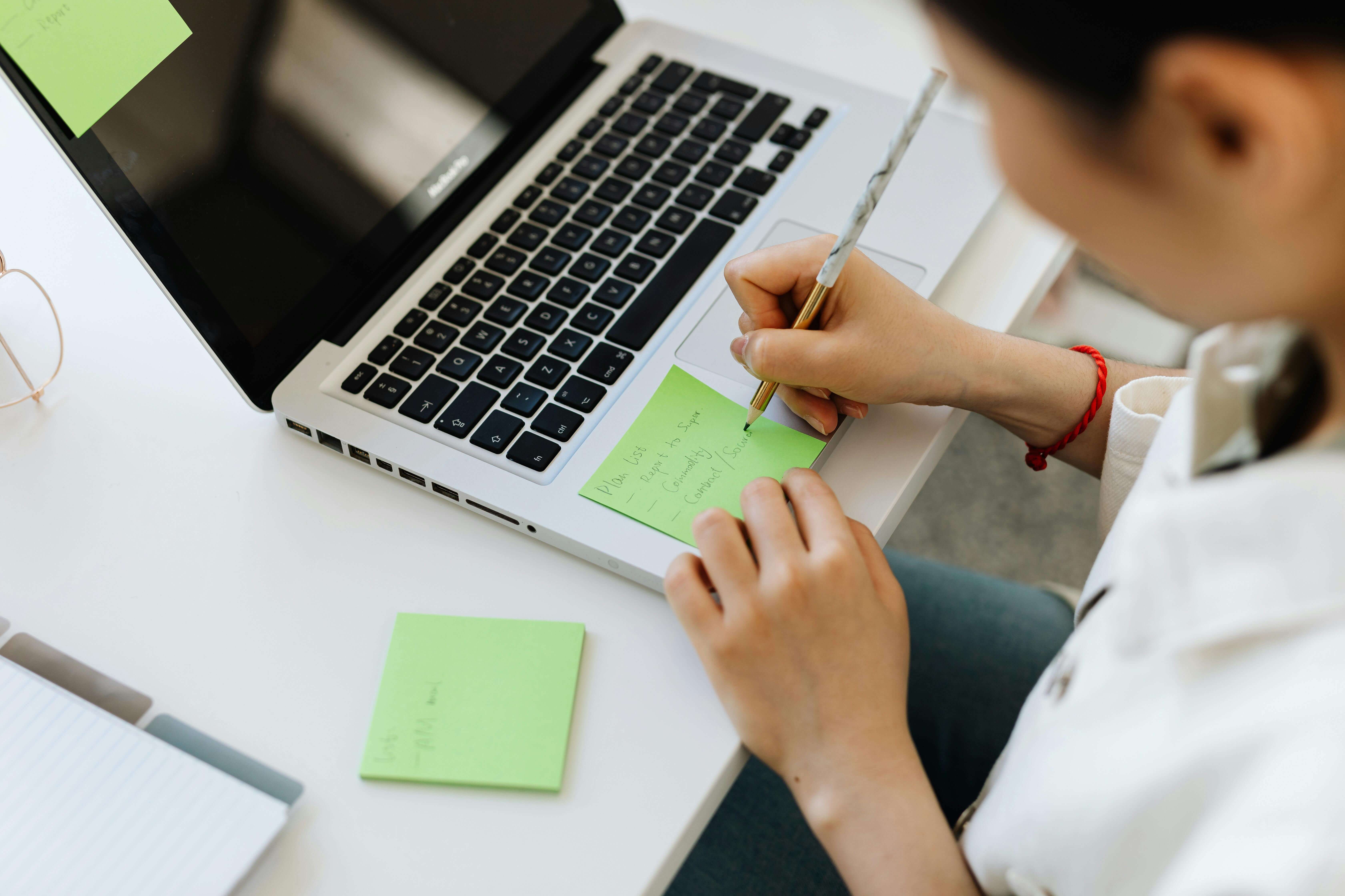 A Person Writing on a Sticky Note