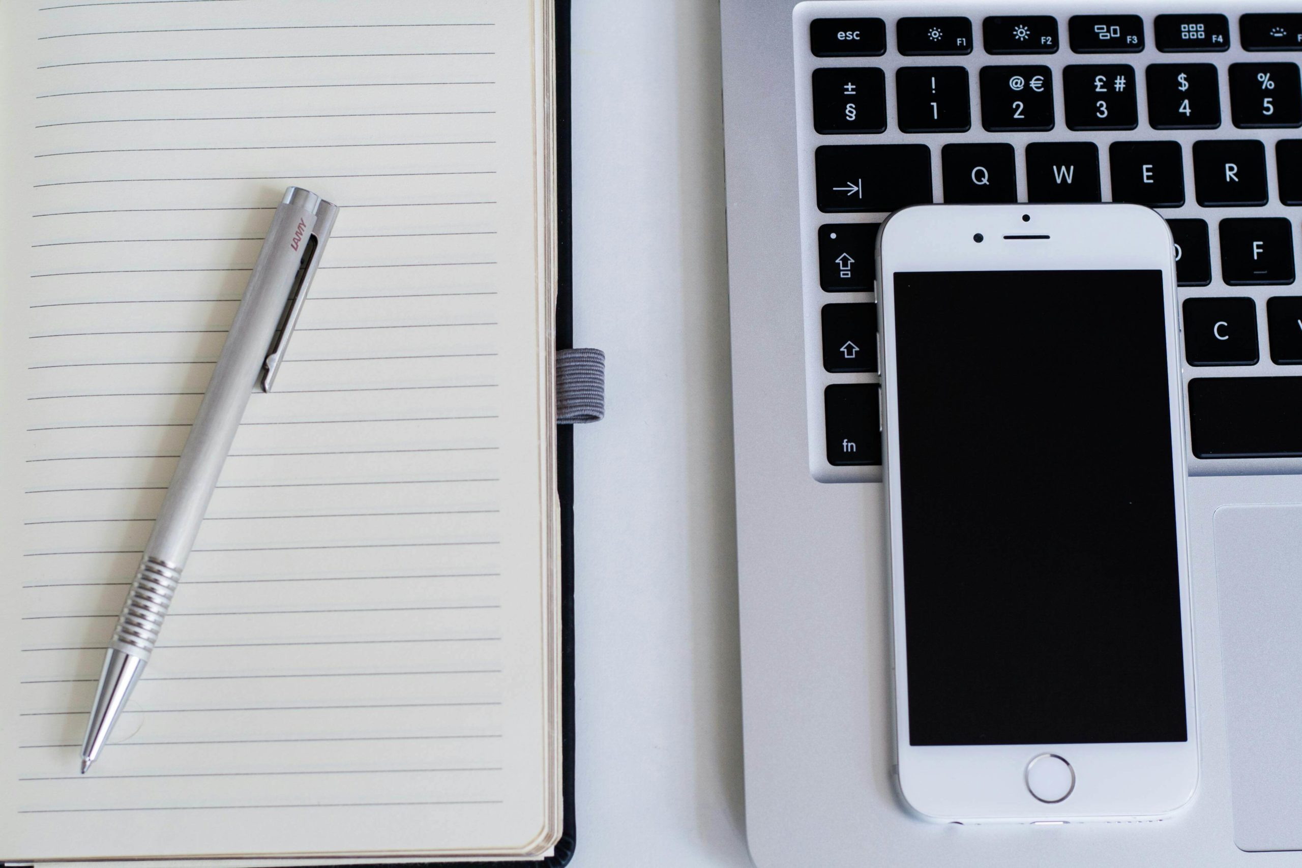 Silver Iphone 6 Near Notebook and Click Pen