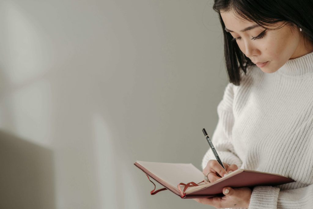 Woman Writing on Notebook