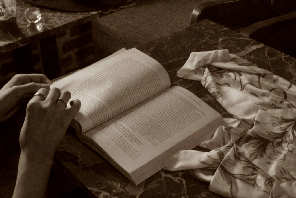 Sepia Toned Photo of a Person Holding a Book