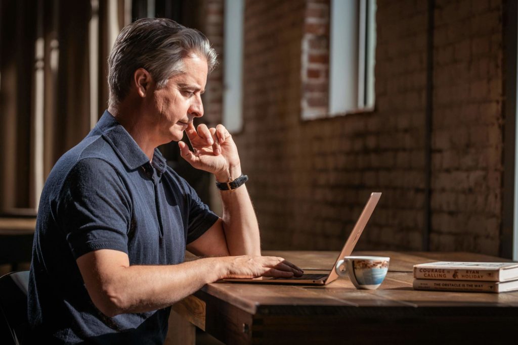 Man Using Laptop at Cafe