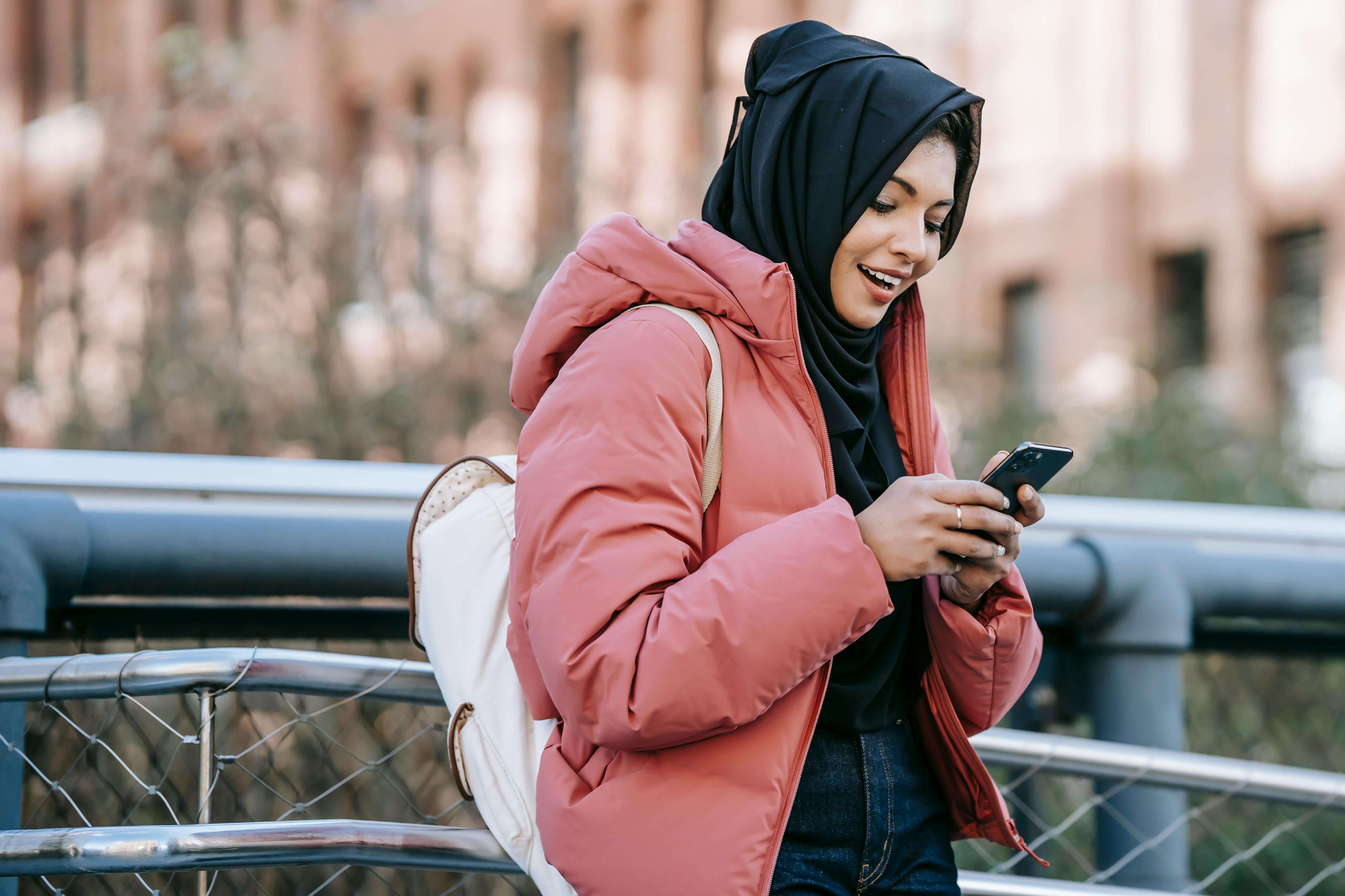 woman in hijab checking smartphone