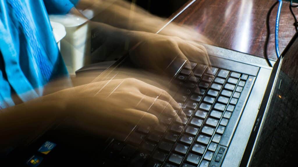 Crop unrecognizable man typing on laptop